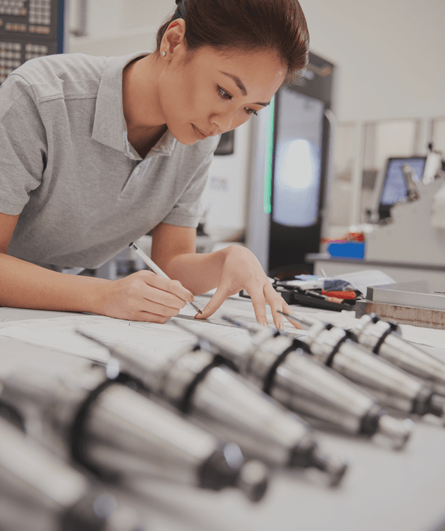 female engineer measuring CAD drawings in factory